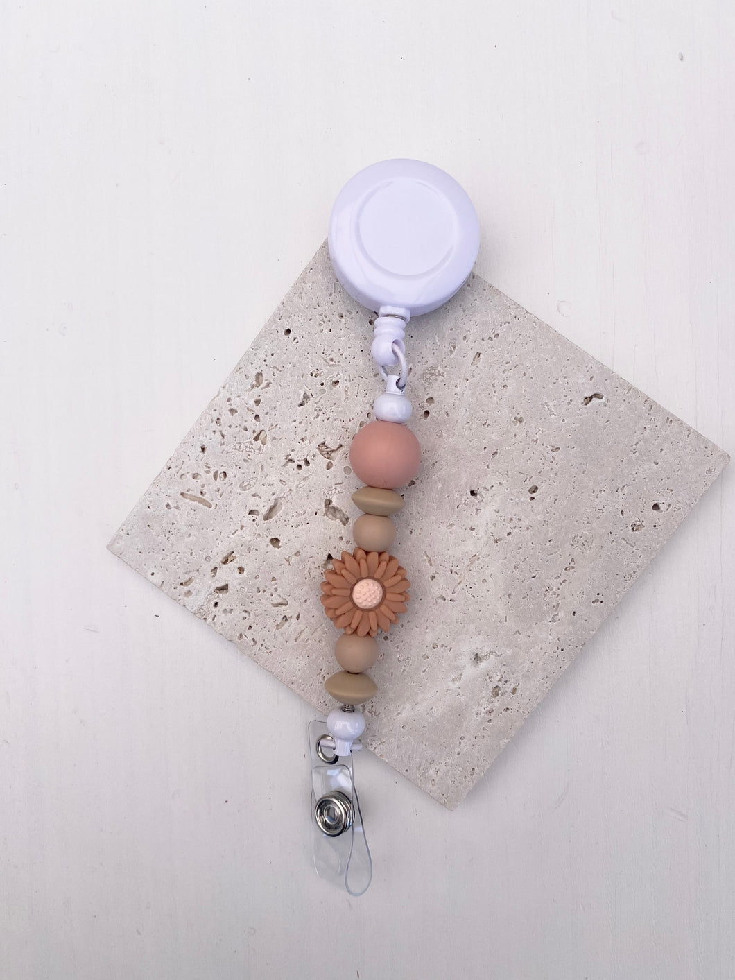 Witte badge met nude daisy en roze